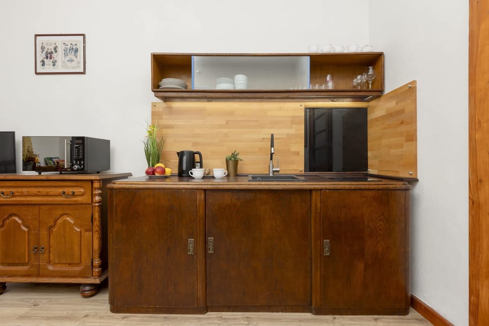 Kitchenette with plenty of kitchen utensils and dishes. 