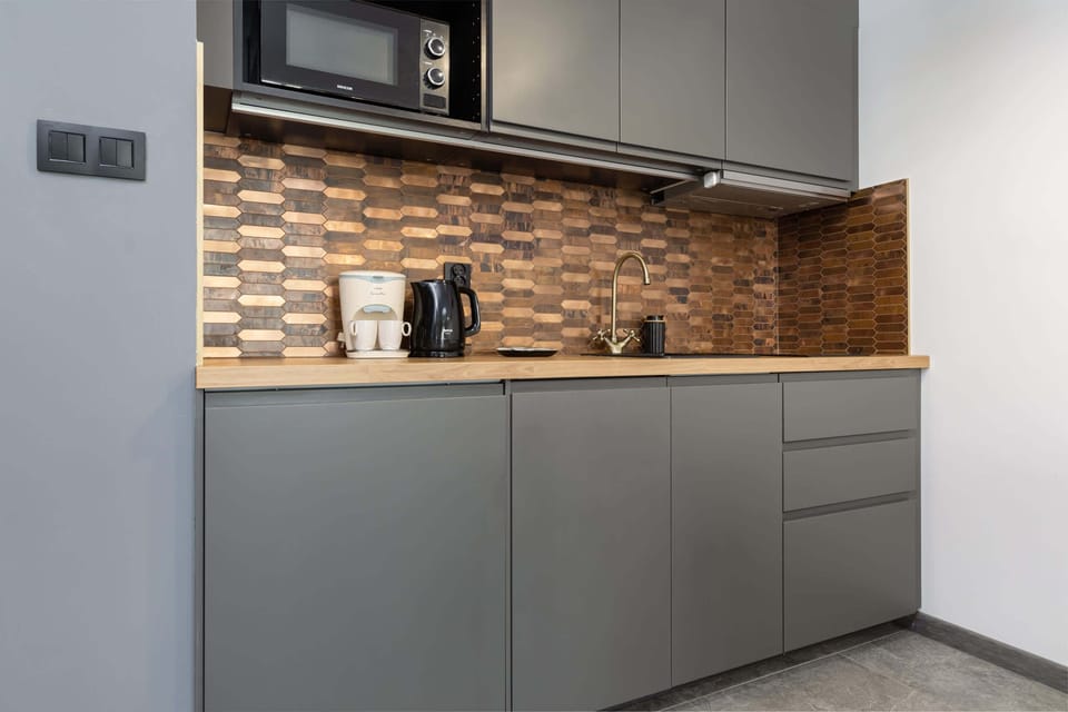 A sleek kitchen with gray cabinetry and a matching dining area nearby, blending practicality with style.