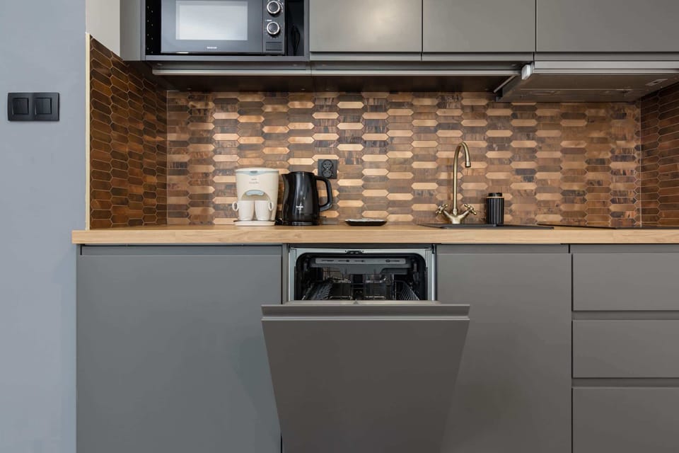 Modern kitchen with grey cabinets and high-quality appliances such as microwave and dishwasher.
