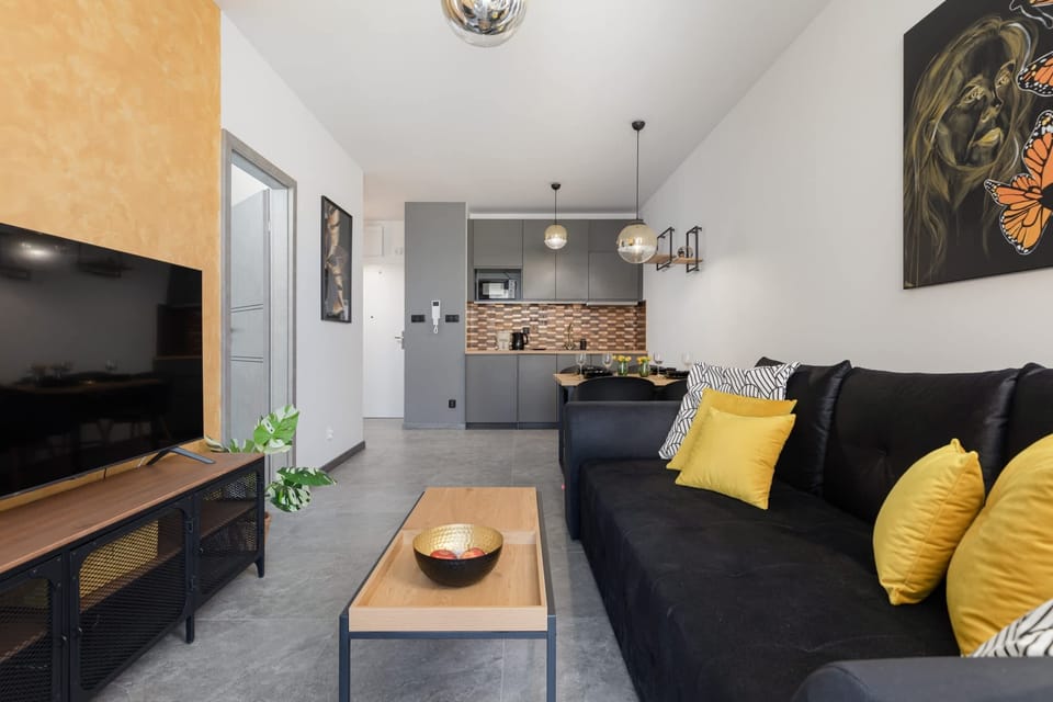  A spacious area combining a living room and dining area, featuring a mix of wooden and dark furniture for a modern yet inviting look.