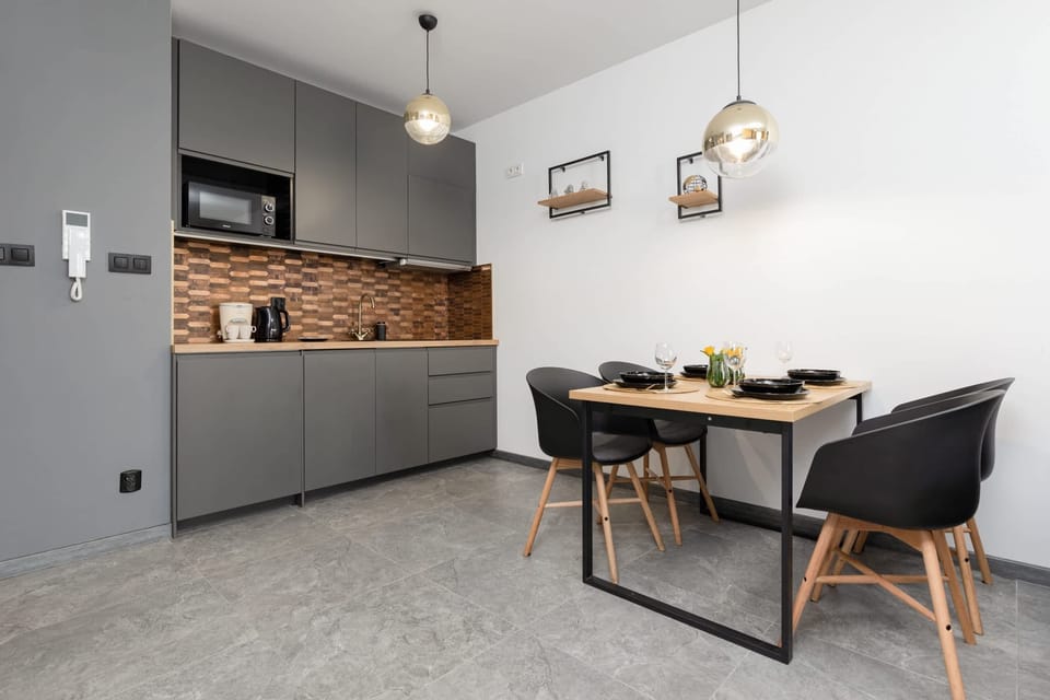 A sleek kitchen with gray cabinetry and a matching dining area nearby, blending practicality with style.