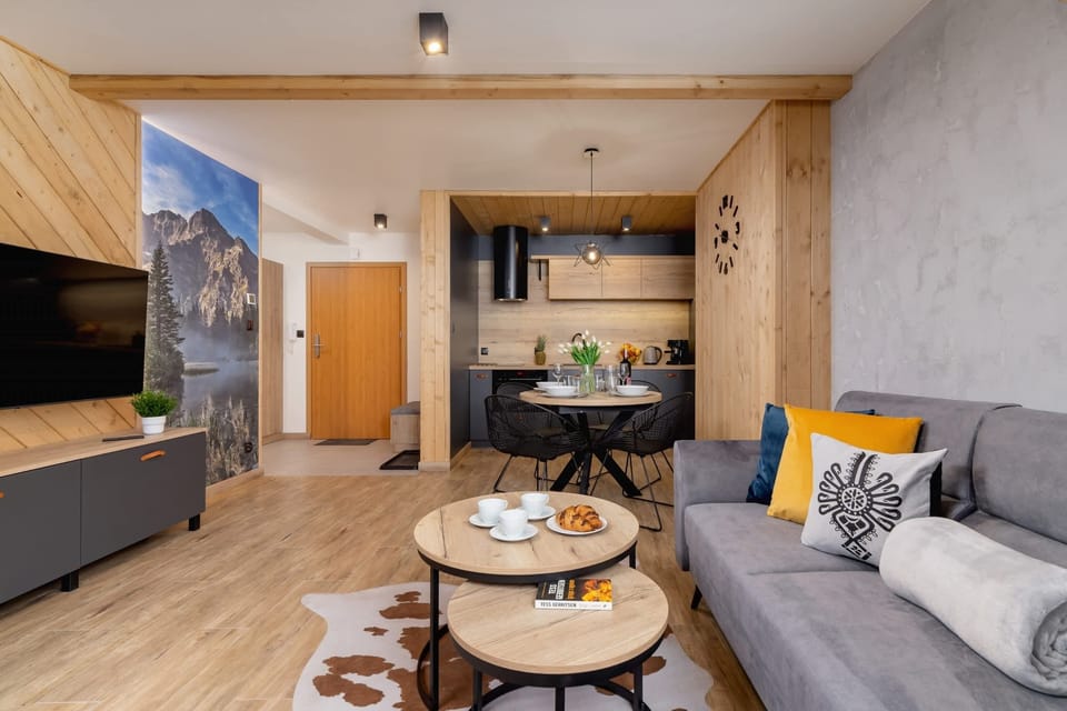 A spacious living area with wooden furniture, modern decor, and warm lighting.