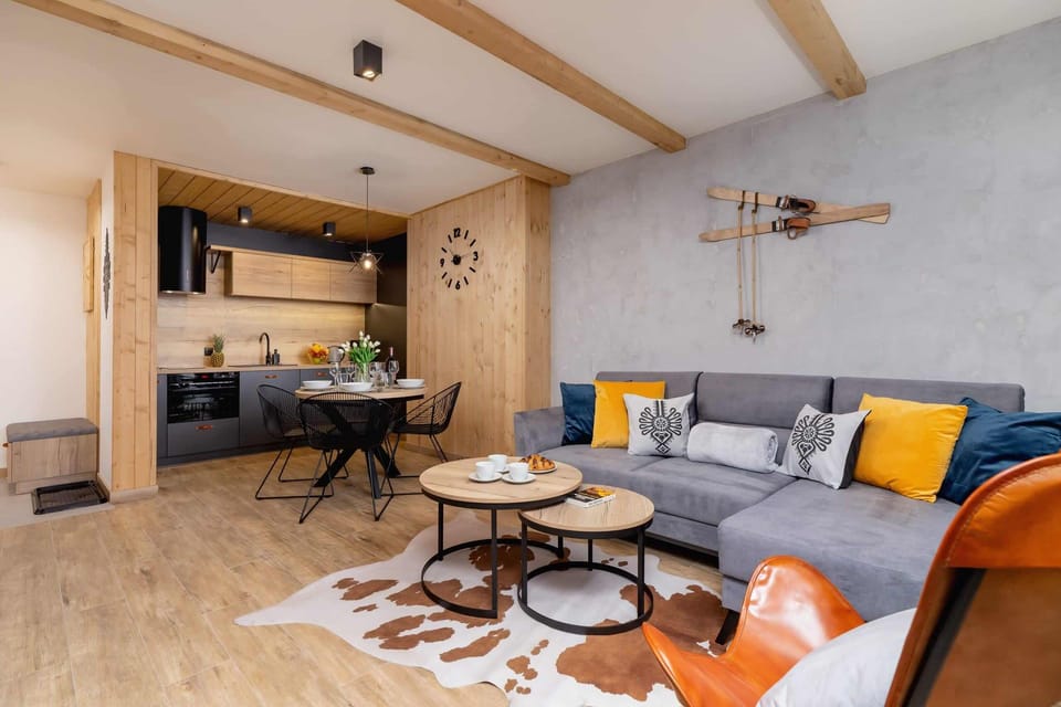 A wider perspective from the living room connected to the dining area. The whole is with a lot of wood which makes the room cozy and warm.