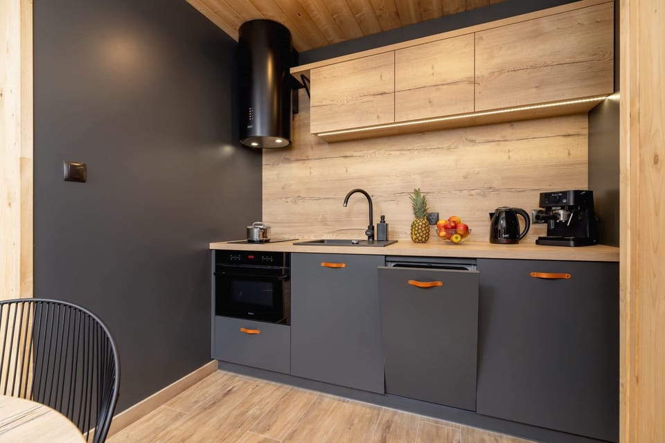 A gray-and-wood-themed kitchen featuring modern appliances and minimalist design.