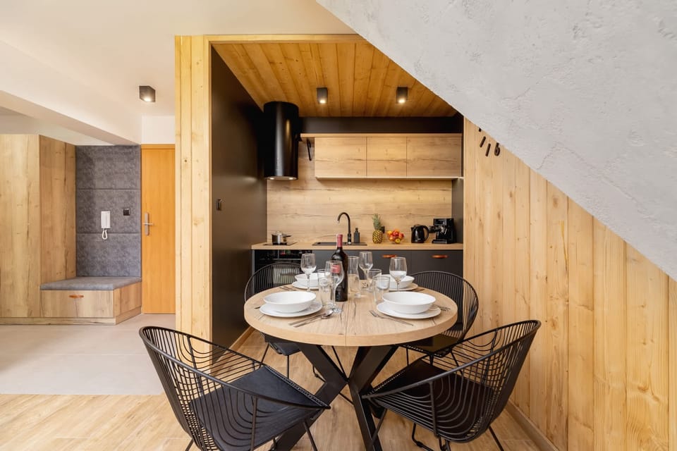 An intimate dining setup with a table for four, wooden accents, and a well-lit ambiance.
