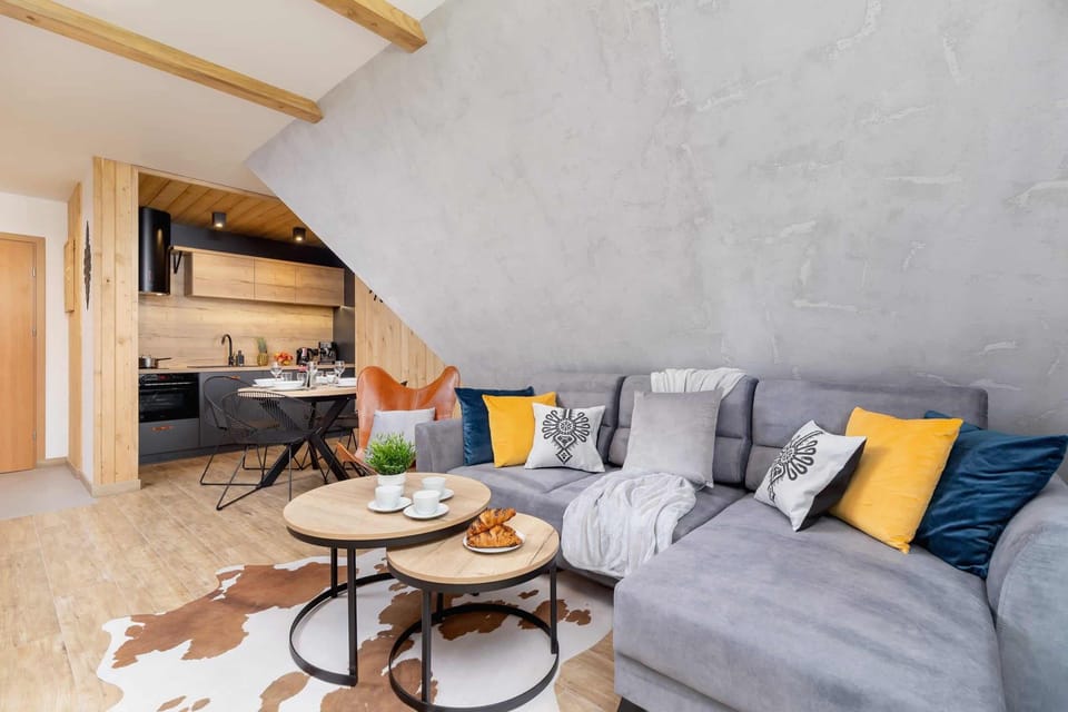 A spacious living area with wooden furniture, modern decor, and warm lighting.