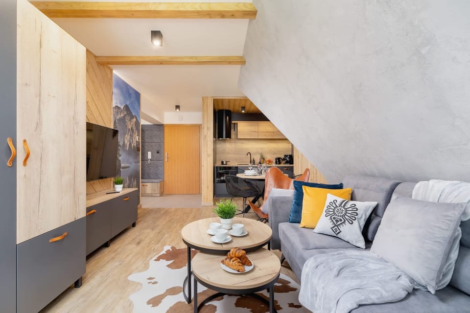 A spacious living area with wooden furniture, modern decor, and warm lighting.