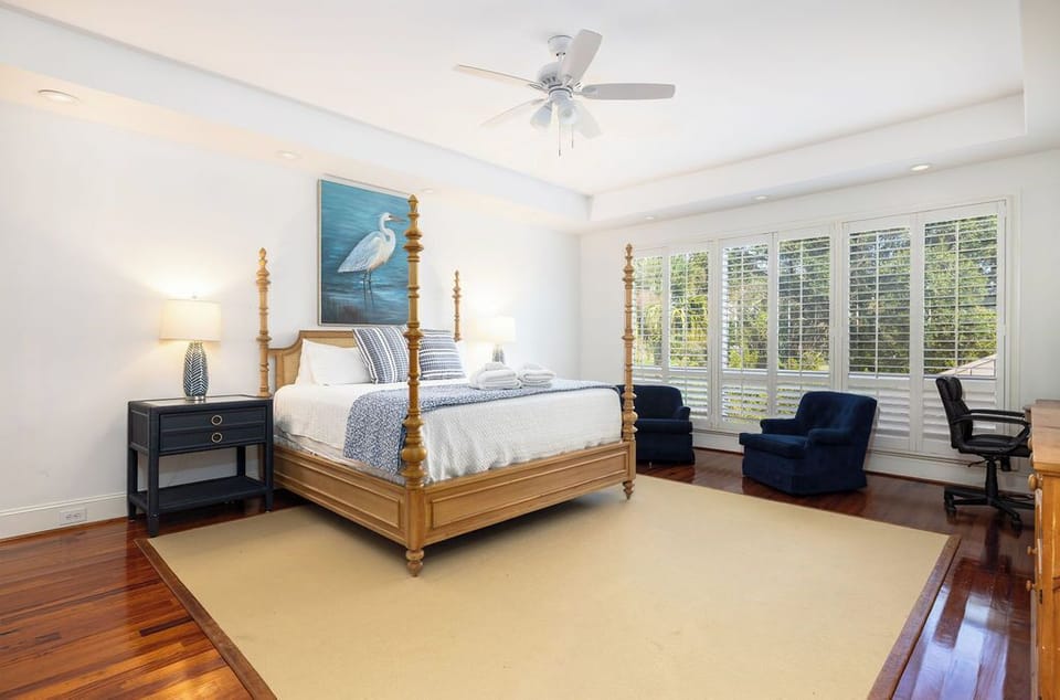 Airy modern coastal bedroom featuring a king bed and smart TV and ensuite bath with a peaceful setting