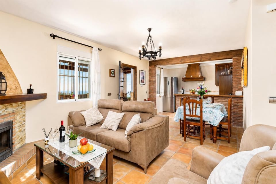 Open-plan living room with sofas, dining area, kitchen, ornamental fireplace, WiFi internet, satellite TV, and sea views