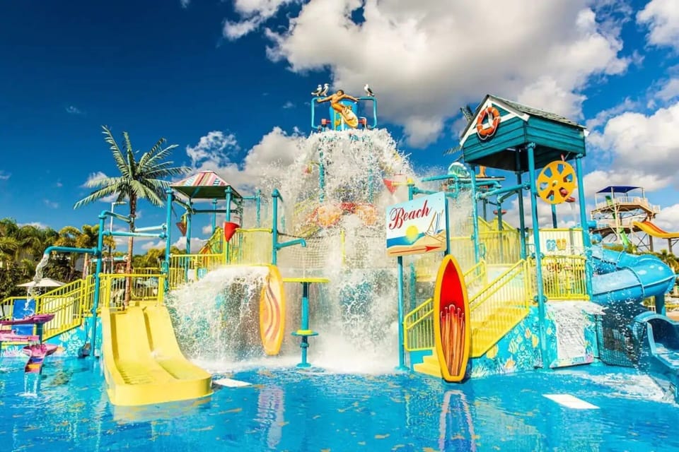 Kids' splash pad has slides and a bucket that dumps water.