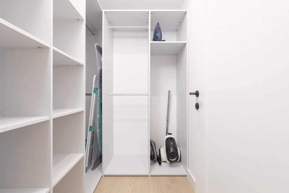 A compact but organized closet with shelves, hangers, and additional storage space.