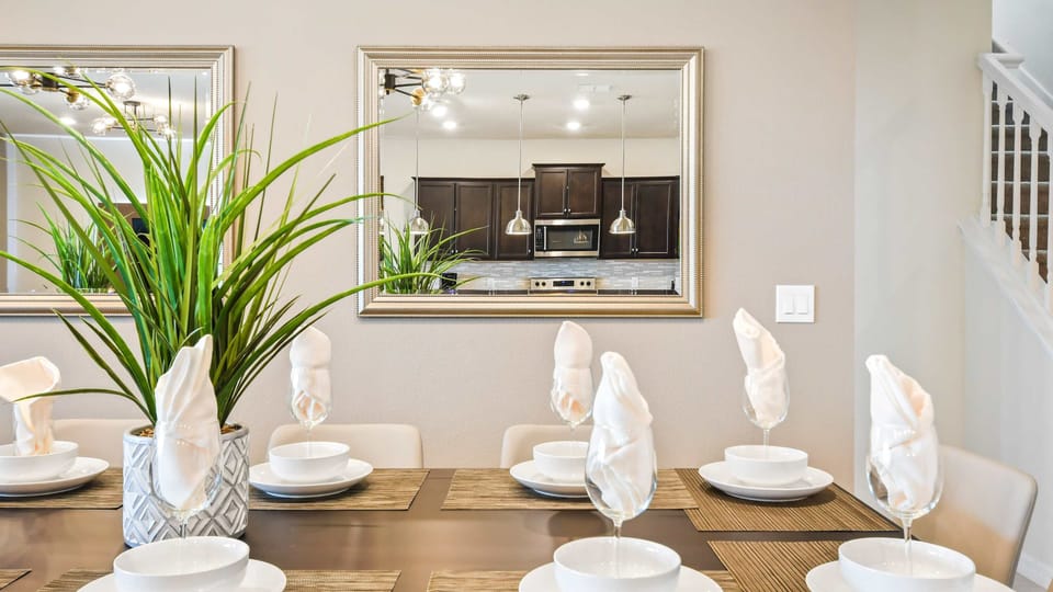 Elegant dining setup with modern decor, mirrored accents, and cozy ambiance!