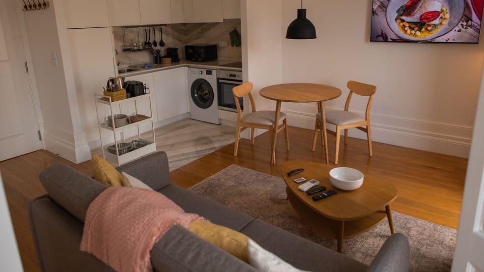 This lovely and ample living area is the perfect spot to spend your free time and to rest after a long day visiting the city, with a flat screen TV for your entertainment #spacious #modern #lovelystay #airbnbporto