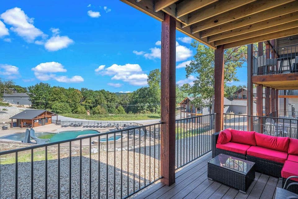Upper deck with dining seating and outdoor couches provides a perfect vantage point for observing the community pool and hot tub
