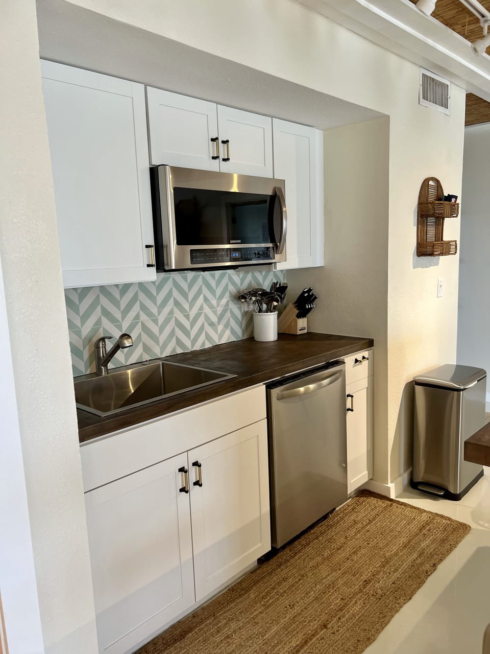 Kitchen with dishwasher and microwave. Electric Ninja air fryer and cooktop. 