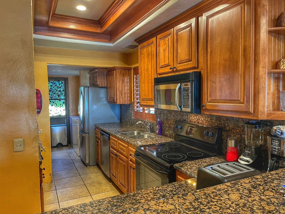 Large kitchen with granite countertops and lots of storage and laundry room .
