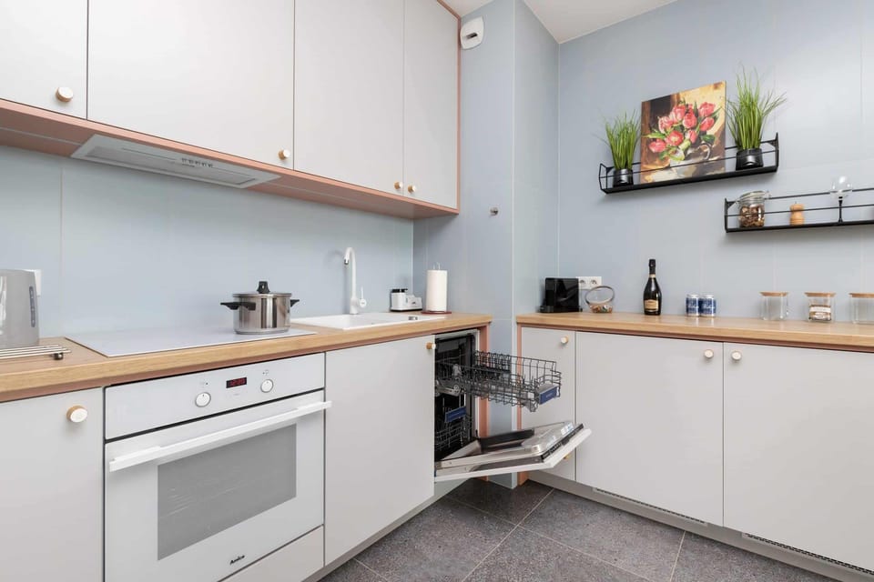 A kitchen space with built-in appliances and organized shelves. It combines functionality with style.