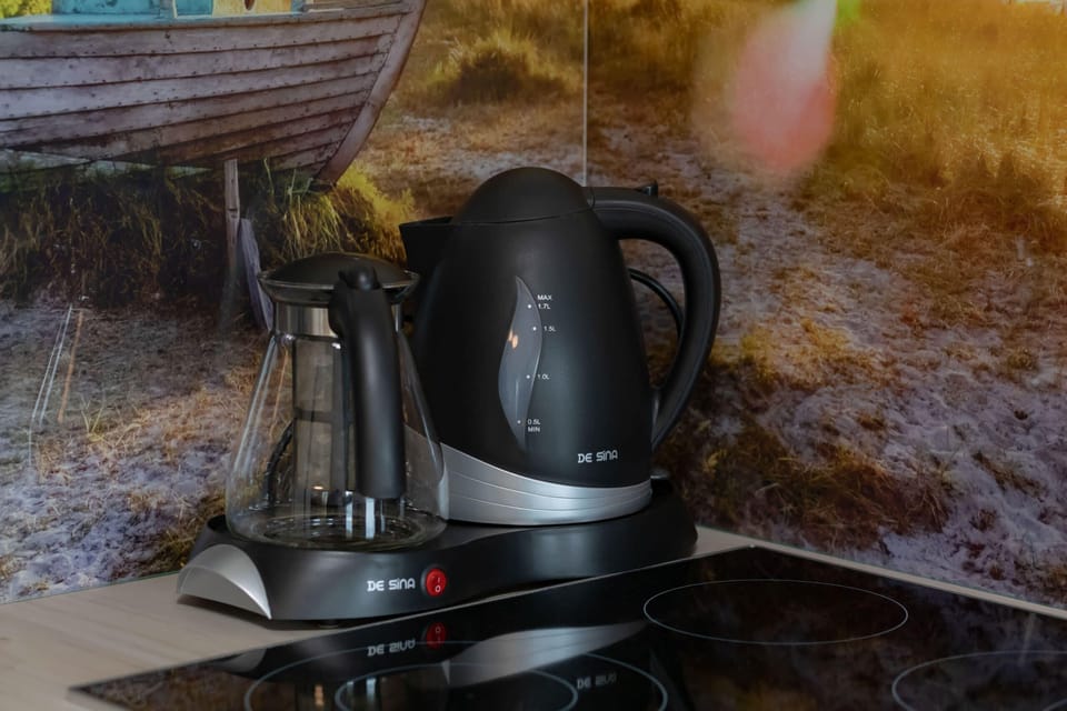 A close-up of a kettle and coffee maker on the counter, perfect for a quick refreshment.
