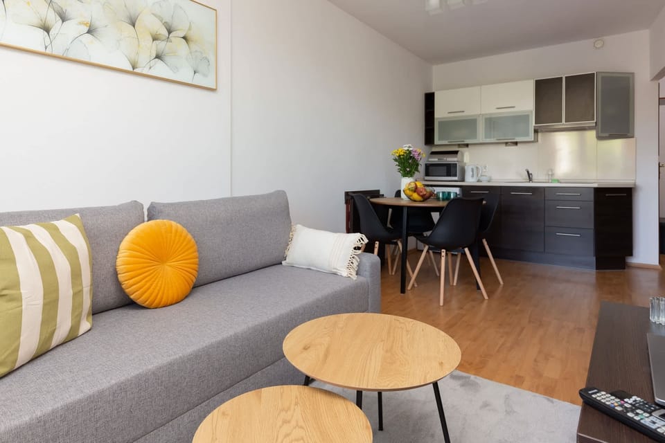 A close-up of the living room with decorative cushions and a round wooden coffee table.
