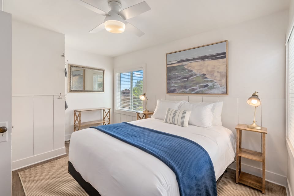 A queen bed and bright windows make the bedroom feel restful