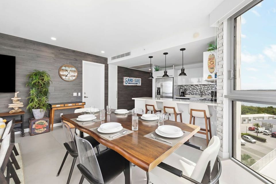 Your bright open-concept space blends dining and kitchen seamlessly, with modern appliances, stylish pendant lights, and coastal decor creating a welcoming retreat perfect for memorable meals and quality time together.