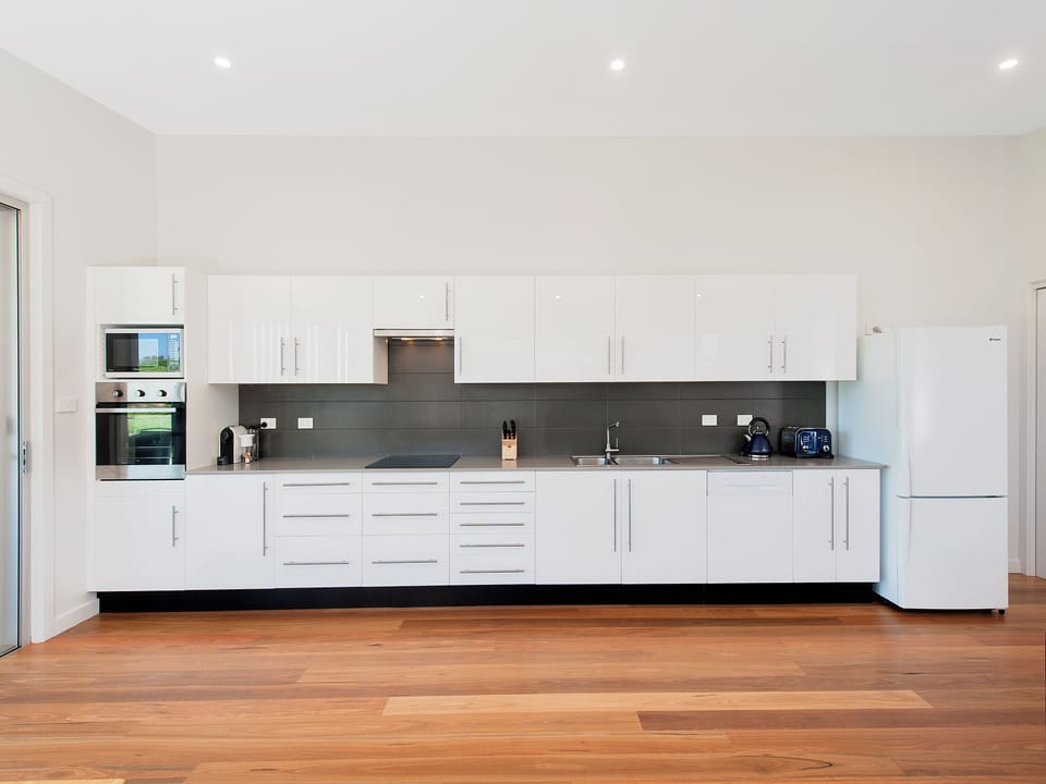 Bright modern kitchen with full-size appliances and warm timber floors