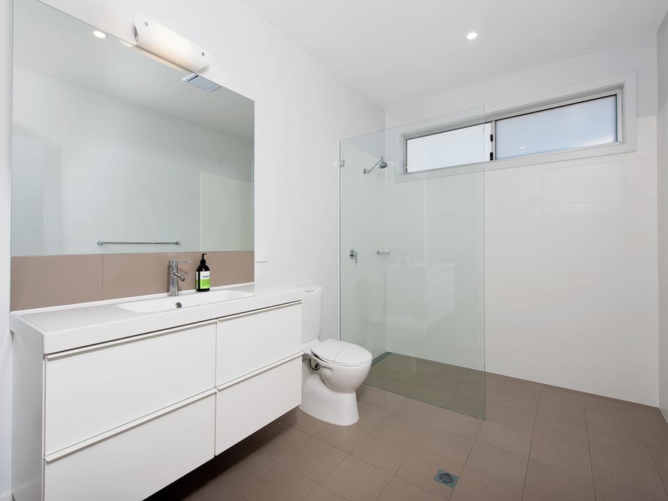 Bright modern bathroom with walk-in glass shower and sleek vanity
