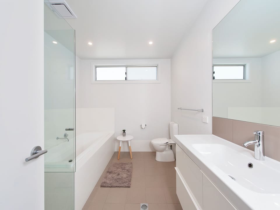 Bright modern bathroom with tub, glass shower & spacious vanity