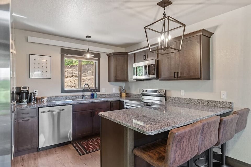 The fully equipped kitchen includes everything you need to cook at home—stove, oven, microwave, fridge, coffee maker, cookware, and utensils.