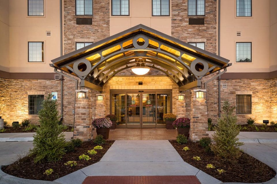 Step into a warm and inviting entrance, framed by beautiful landscaping.