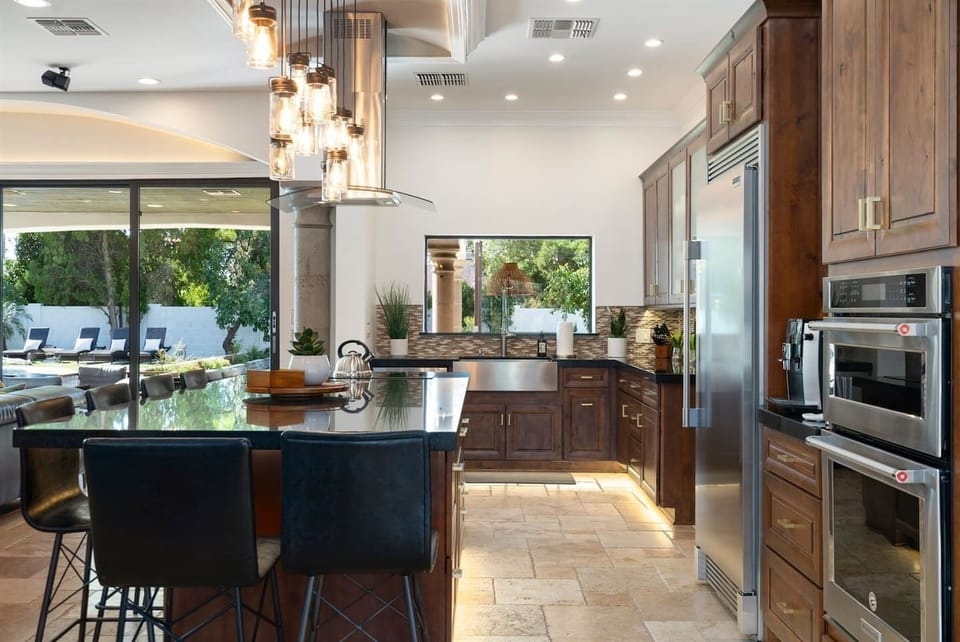 Elevate your dining experience! This stylish kitchen and dining area boast chic ceiling lights and a large fridge for all your culinary creations. Gather, feast, and enjoy!