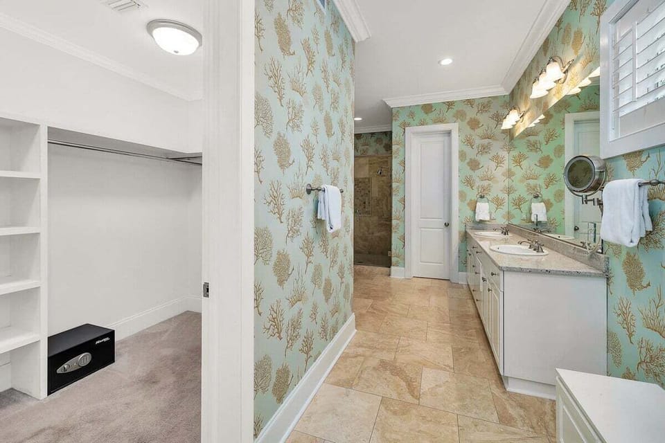 Primary bathroom with large mirror and access to walk in closet