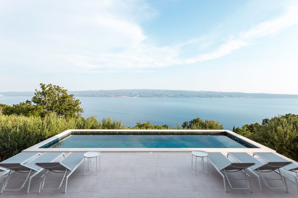Villa Marmoris pool area with sunchairs and outdoor shower. 