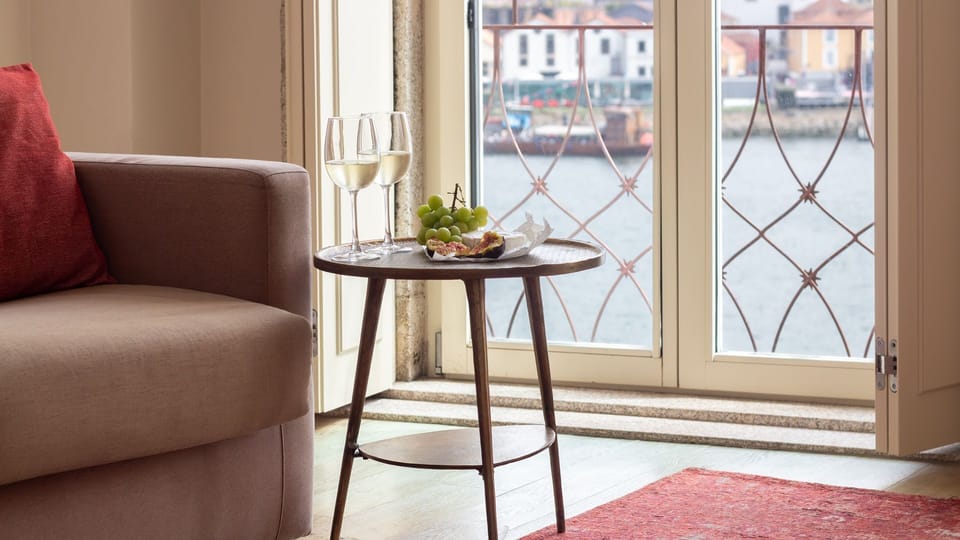 Unwind with a glass of wine by the window, where the serene river view creates a perfect backdrop for relaxation.
#LivingArea #RiverView #LovelyStay