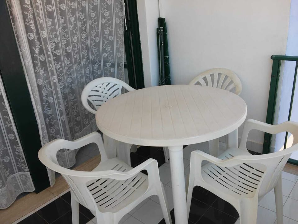 Balcone verandato con tavolo e sedie in plastica