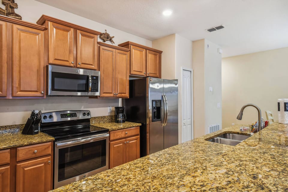 Experience a beautifully designed kitchen featuring warm wood cabinetry and rich granite countertops. The sleek stainless steel appliances blend style and functionality, while natural light creates an inviting atmosphere for your.
