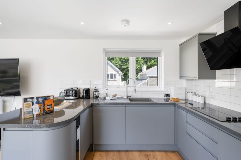 The Cube, Portreath. First floor: Well equipped kitchen with breakfast bar, electric hob, fan-assisted oven, microwave, fridge/freezer, dishwasher, and a small wine chiller