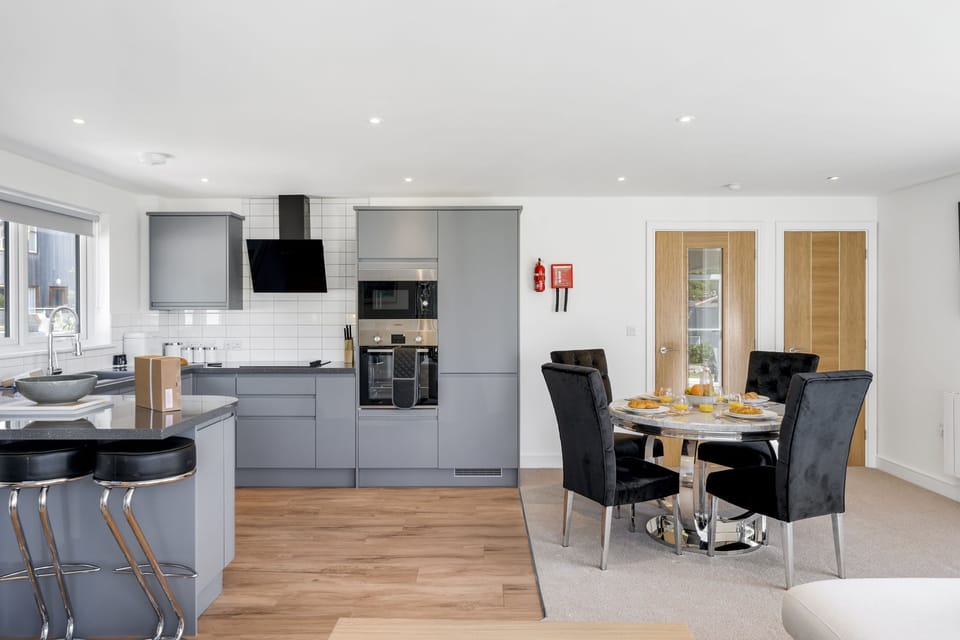 The Cube, Portreath. First floor: Stainless-steel dining table with four velvet padded chairs.