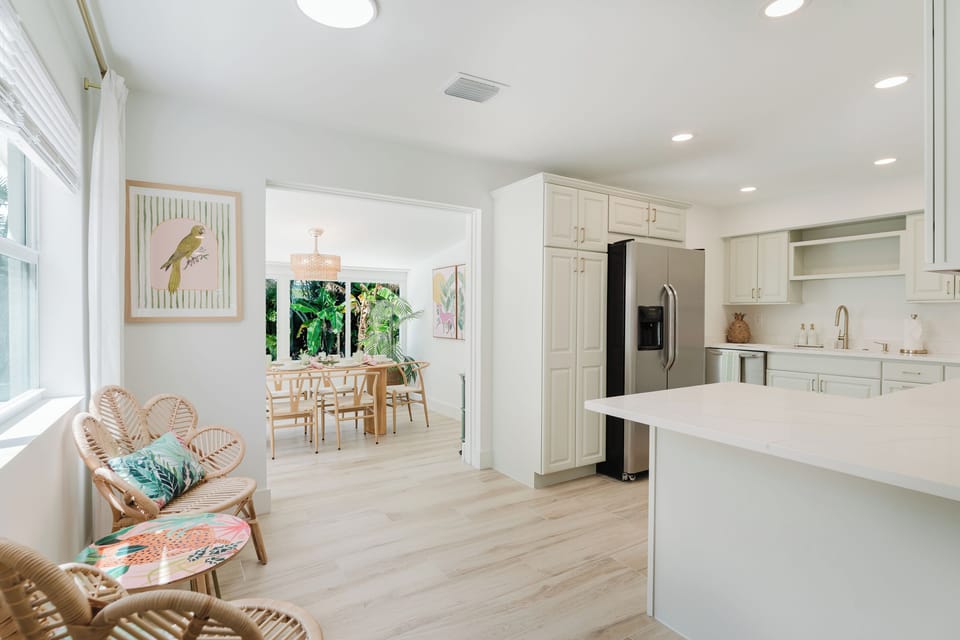 Bright and inviting breakfast nook with oversized windows overlooking the tropical backyard. The perfect spot to enjoy your morning coffee, read a book, or gather before a day of exploring South Florida.

