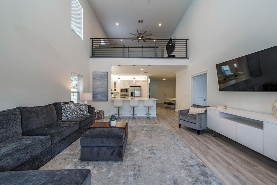 A wide-open floor plan with plush seating and views to the upstairs loft — designed for relaxation and gathering on vacation time