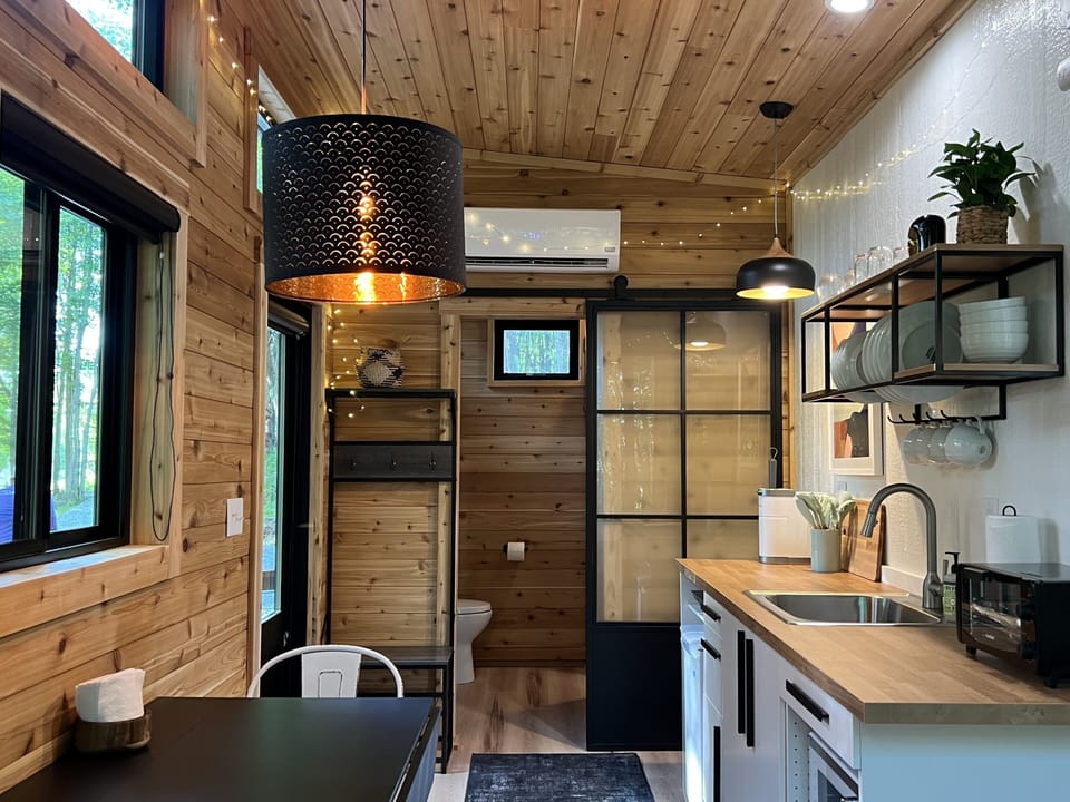 The bathroom is separated from the main living space with a sliding steel door with frosted glass for privacy.  