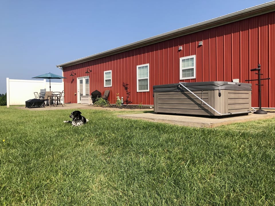 Patio includes a dining table, grill, fire pit and hot tub.