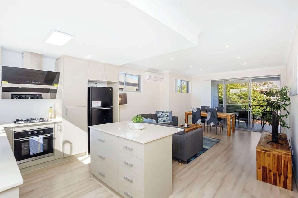 Your comfortable getaway features powerful AC for all seasons! The modern kitchen boasts a convenient stove for your culinary creations, leading seamlessly into a spacious living room space, also equipped with AC for your absolute comfort.