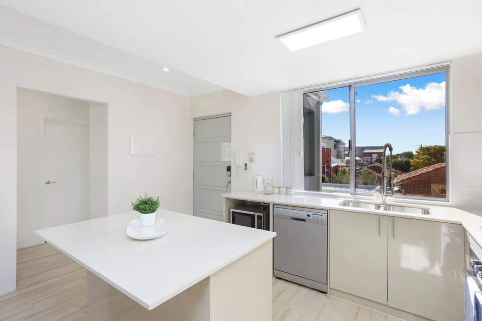 Whip up your favorite meals in this bright and modern kitchen, complete with essential appliances and ample counter space, bathed in natural light.