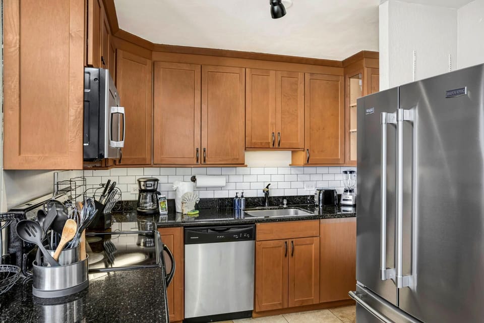 This kitchen pairs warmth and polish—where dark countertops, subway tiles, and sunshine make every bite feel brighter   