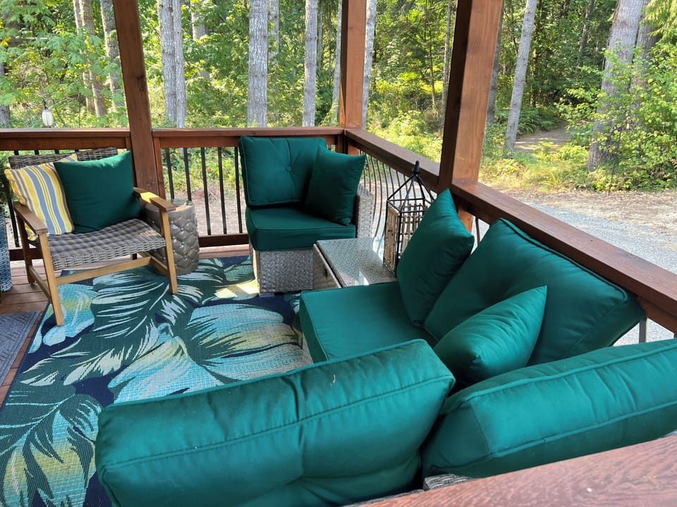 COvered outdoor lounge surrunded by trees- relax rain or shine