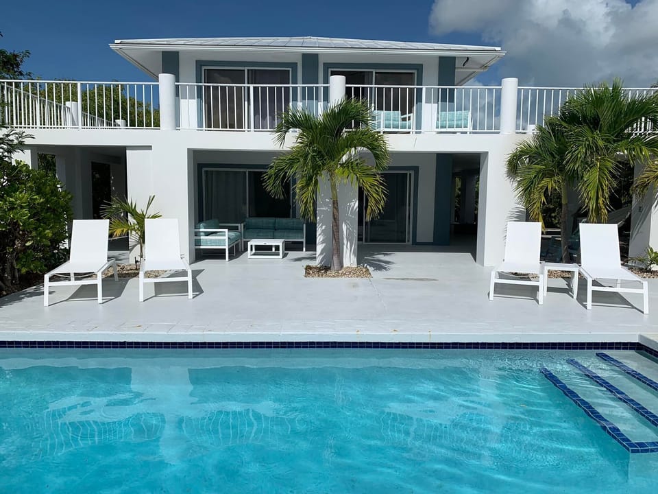 view from across the pool. New pool loungers and conversation sets.