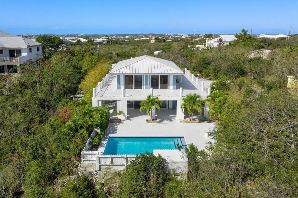 Aerial view of the front side of the house showing spacious patios and pool deck