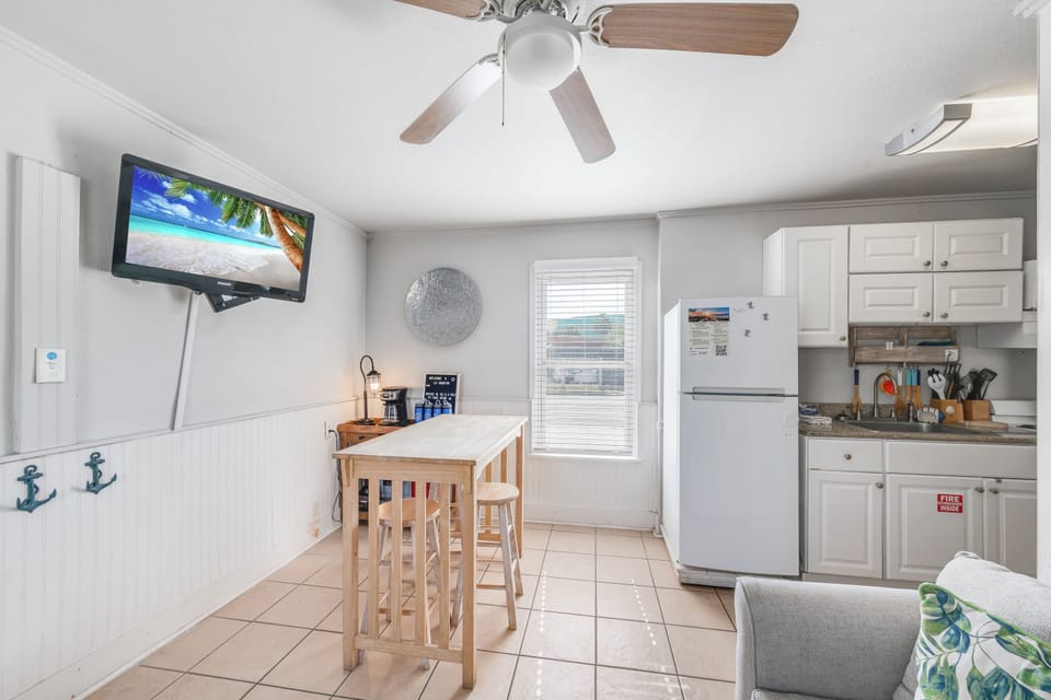 Your bright kitchen invites you to prepare morning coffee while watching the sunrise on TV, complete with coastal charm.