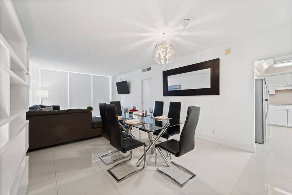 Seamless open-concept living and dining space with modern furniture, seating for 8+ guests, and contemporary design. Perfect for large families or groups to enjoy meals and entertainment together.